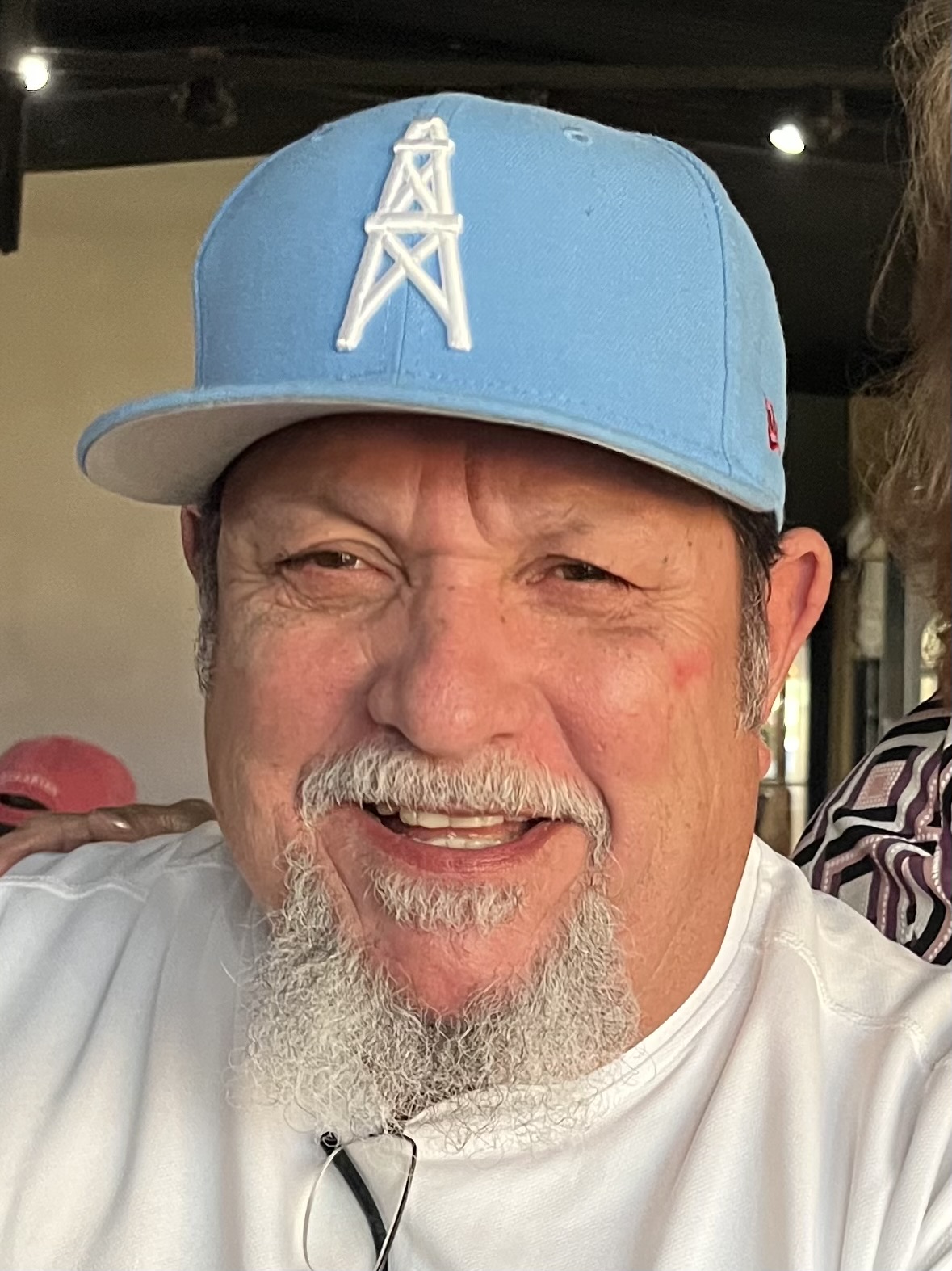 A man with a beard and hat smiles for the camera