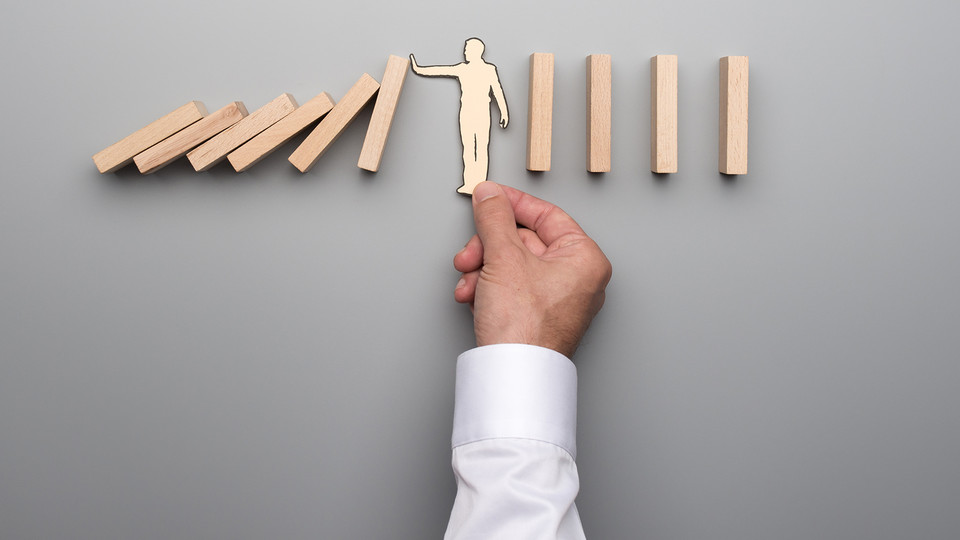 A man is pointing to a wooden board with a person on it